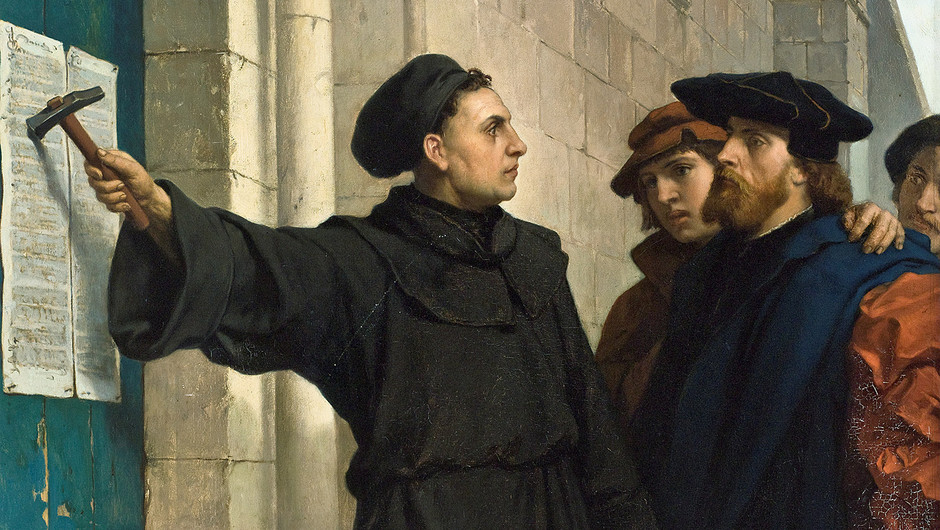 Gemälde von Ferdinand Pauwels von 1872 mit dem Titel „Luthers Thesenanschlag“. Zu sehen ist Martin Luther, wie er gerade mit einem Hammer seine 95 Thesen an die Wittenberger Schlosskirchentür geschlagen hat. Andere Menschen schauen ihm dabei zu.