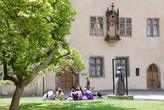 A group of vsitors sitting in the courtyard of the Luther House / Augusteum
